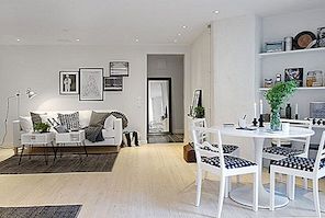 En liten, vit lägenhet med svarta accenter och moderna möbler