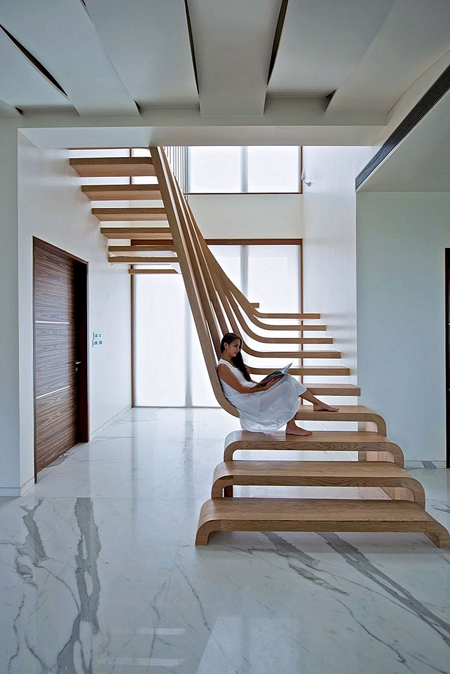 Skulpturell trappa definierar en modern två våningar lägenhet i Mumbai