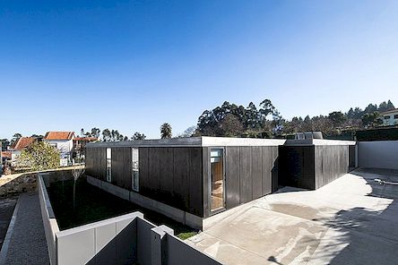 Černá betonová budova s ​​minimalistickou architekturou: dům v Mosteiro