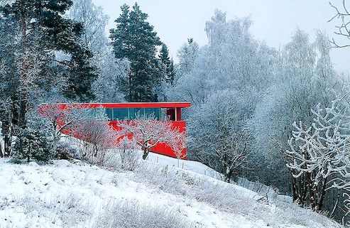 Jasný červený dům, který se nachází v norském údolí řeky