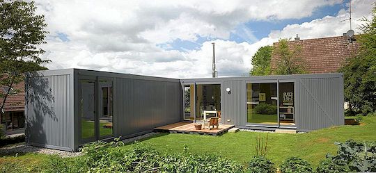 Kompaktní atipický domovský tvar ve tvaru L umístěný ve venkovské krajině v Německu