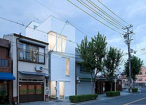 Hallå vita lådor och generösa fönster som definierar smal hem i Osaka