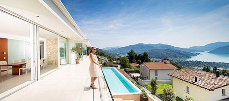 Masivní bílá silueta nad jezerem Lugano, Švýcarsko: Dům Lombardo
