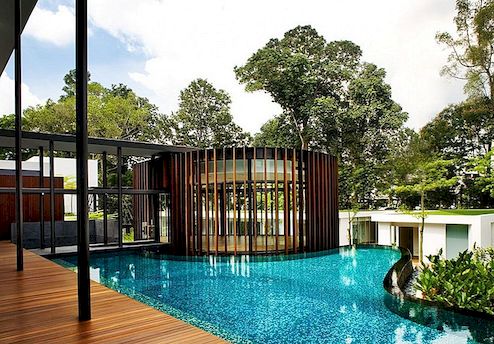 Modern huis met kronkelig paviljoen die zich vermengen met het natuurlijke landschap