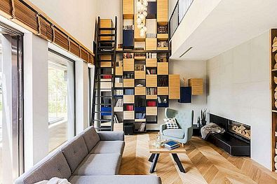 波兰的现代住宅突出了从地板到天花板的书柜