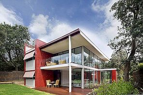 Rode muren en glinsterende vinnen bepalen een modern huis in Australië
