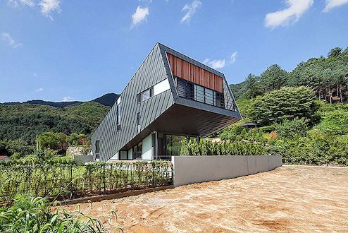 Ongebruikelijk met zink bekleed leunend huis verstoort het heuvellandschap