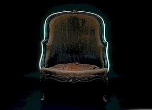 De antieke Bérgere-stoel versierd met een turquoise neon